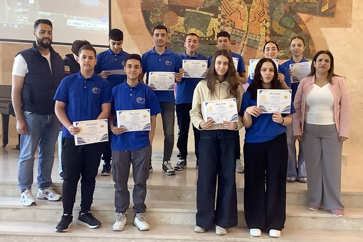 Ein dutzend Schülerinnen und Schüler von Talitha Kumi stehen umrahmt von einer Lehrerin und Lehrer auf der Bühne der Kapelle von Talitha Kumi. Sie zeigen Zertifikate, die sie für die Teilnahme am Projekt "Together We Connect" erhalten haben.